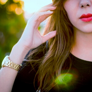 a woman wearing a yellow gold watch for ladies